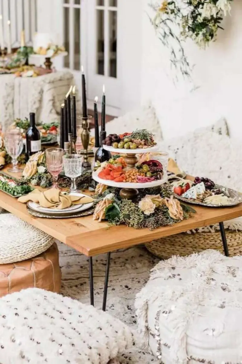 mesa de petiscos estilo bo&ecirc;mio com decora&ccedil;&atilde;o em tons neutros e velas pretas