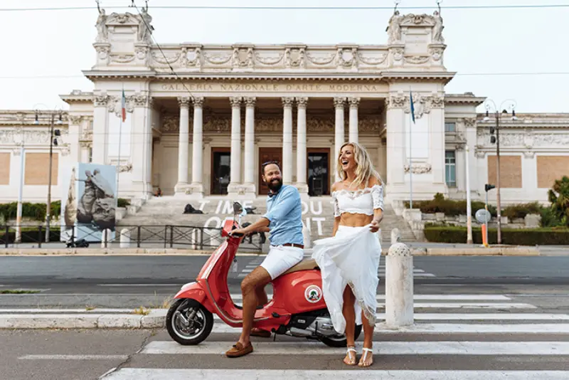 casal alegre na rua com vespa
