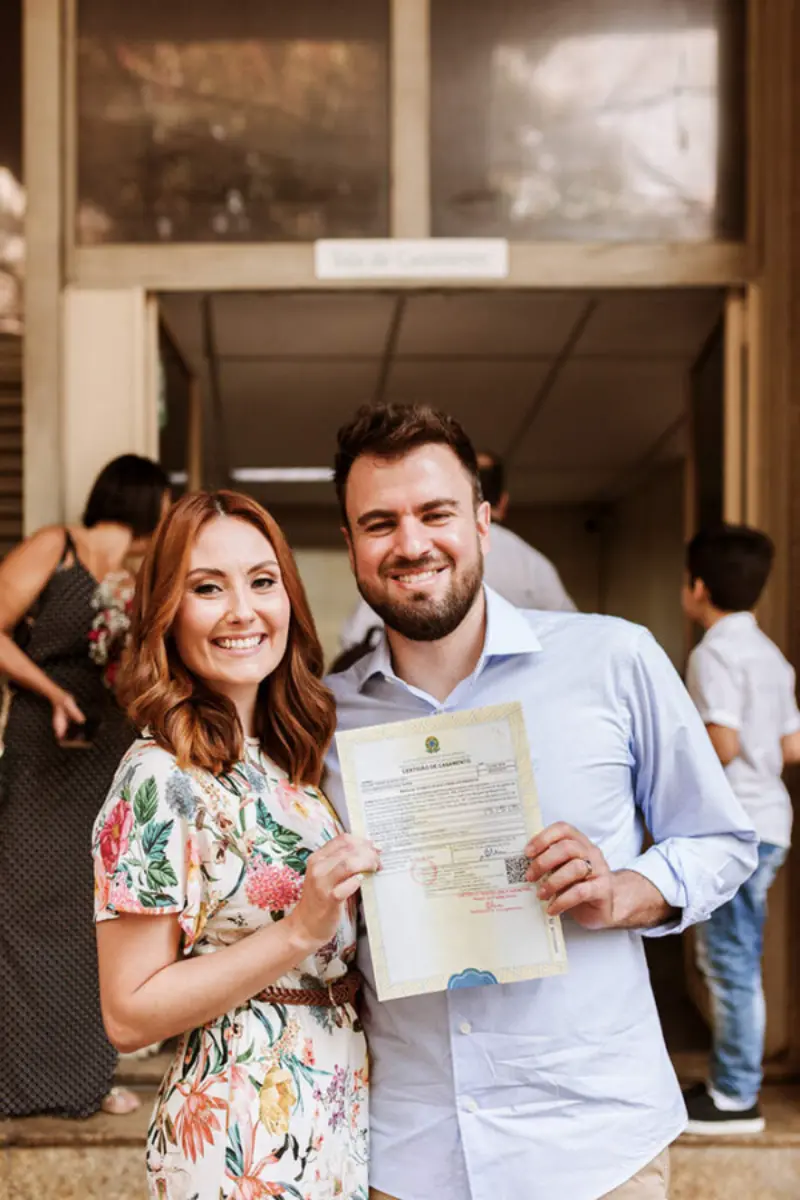 casal saindo do cart&oacute;rio com certid&atilde;o de casamento