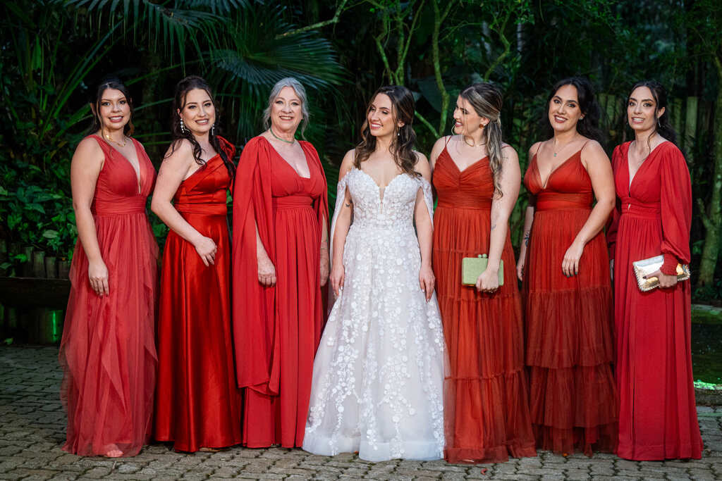 noiva ao lado das madrinhas de vestido vermelho