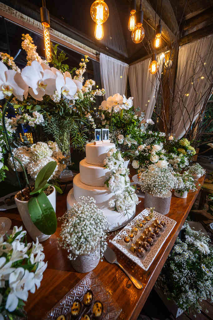 mesa com bolo de casamento e plantas