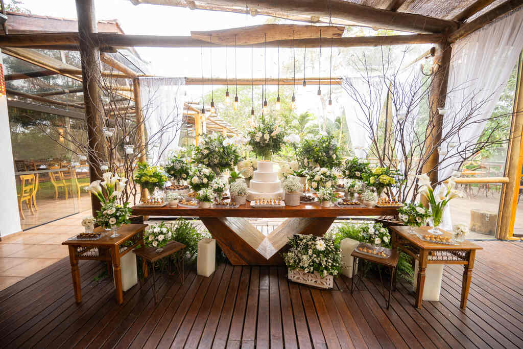 mesa com bolo de casamento e plantas