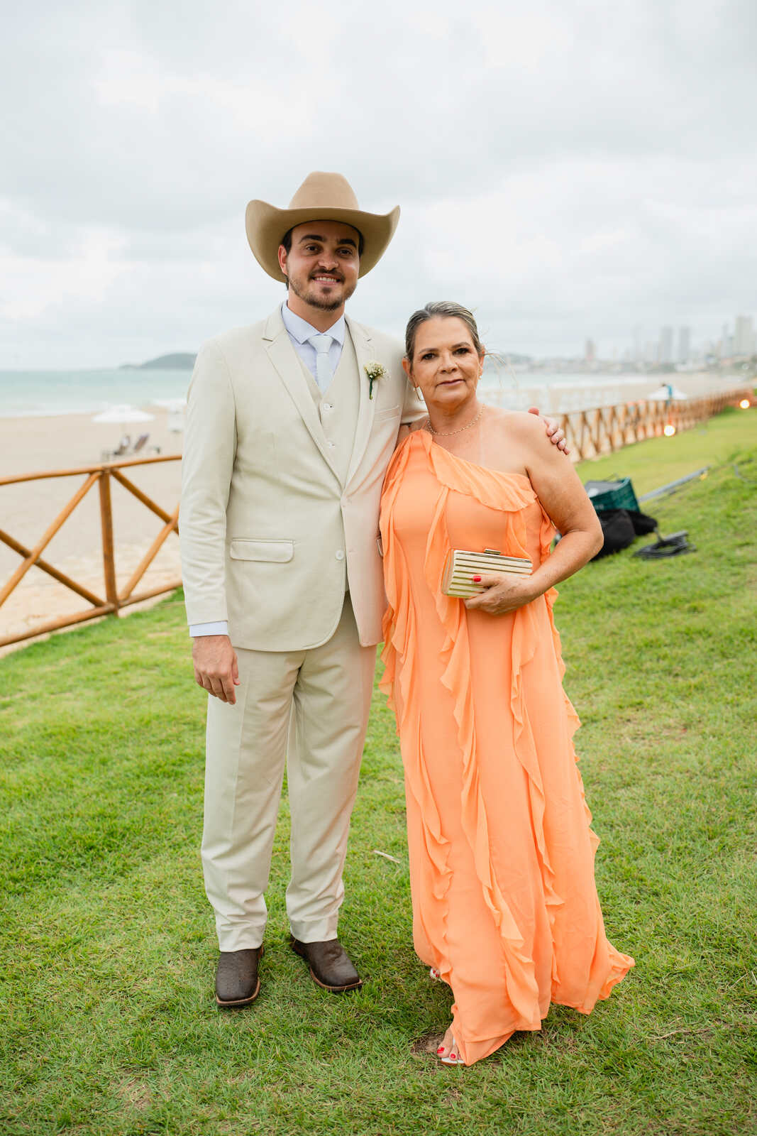 noivo com a mãe de vestido laranja