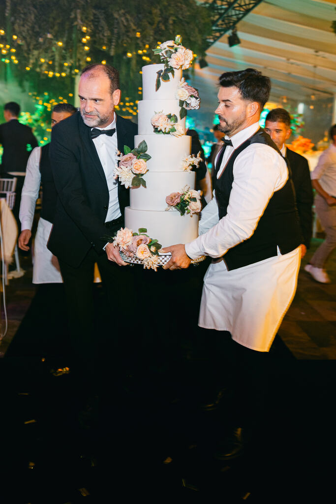 homens segurando bolo de casamento