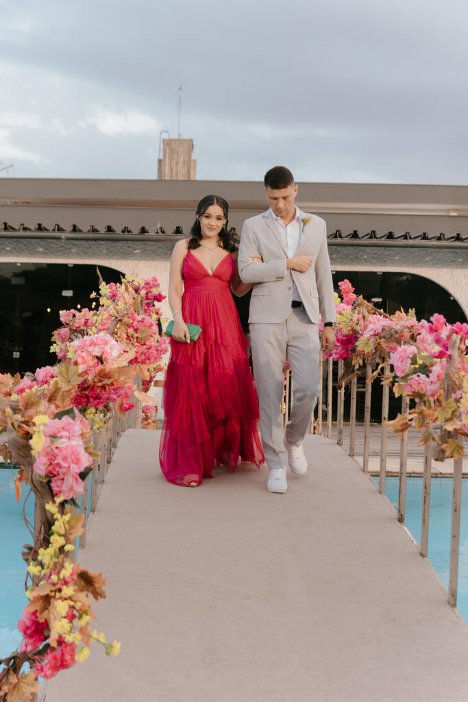 entrada da madrinha de vestido rosa e padrinho de terno cinza