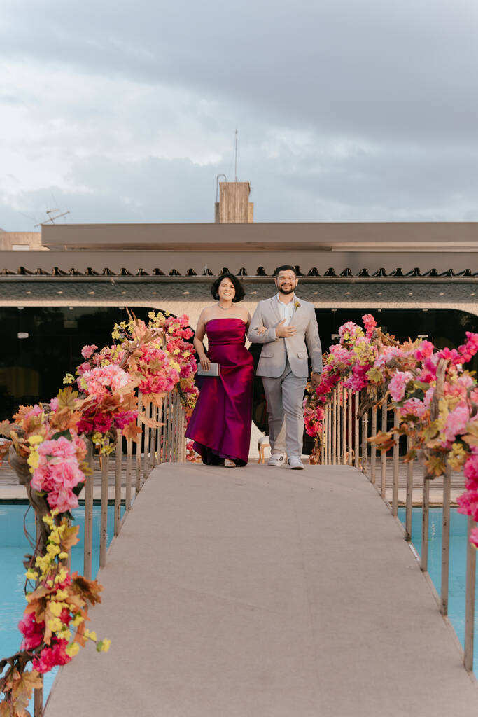 entrada da madrinha de vestido rosa e padrinho de terno cinza