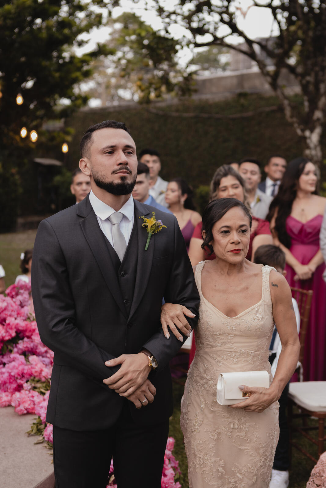 noivo com terno preto ao lado da mãe com vestido creme