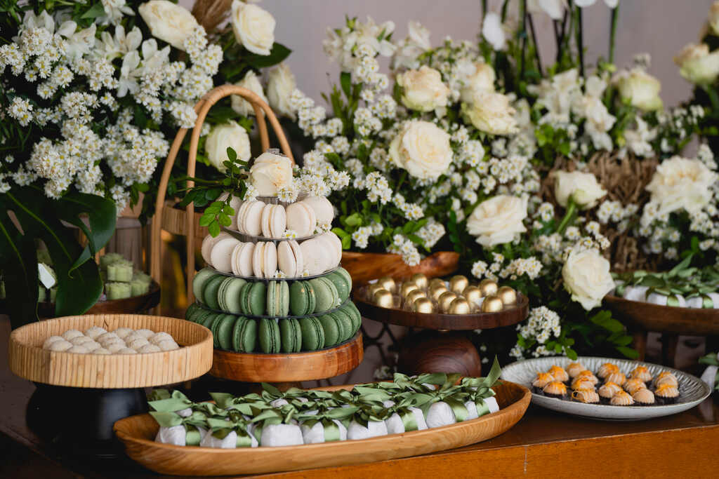 mesa com doces de casamento e flores brancas