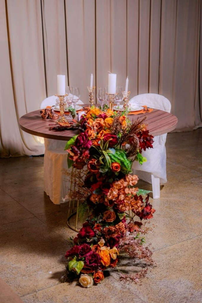 mesa dos noivos com flores vermelhas e laranjas