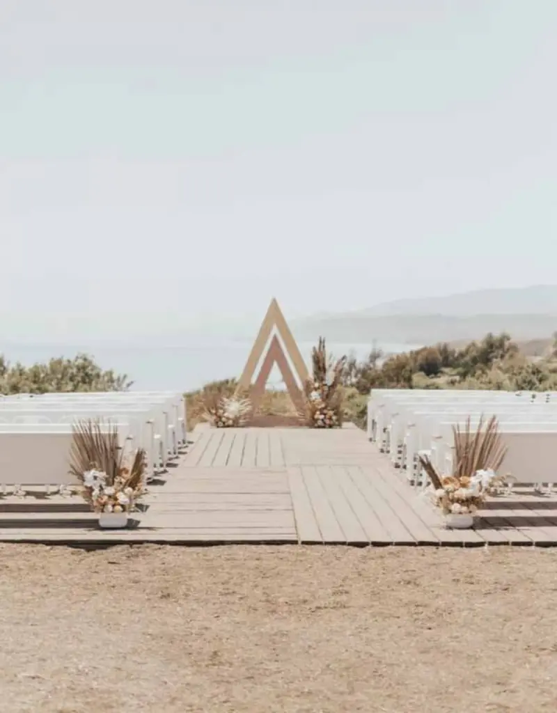 decora&ccedil;&atilde;o de cerim&ocirc;nia de casamento r&uacute;stico ao ar livre com um arco triangular de madeira