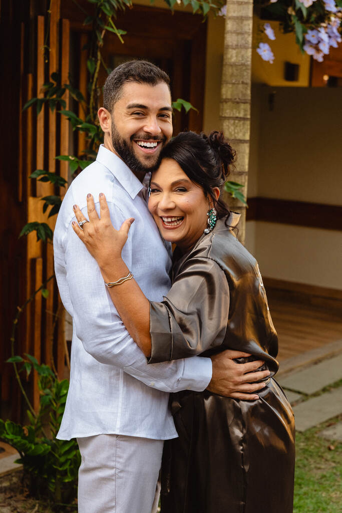 noivo abraçado com a mãe de robe verde