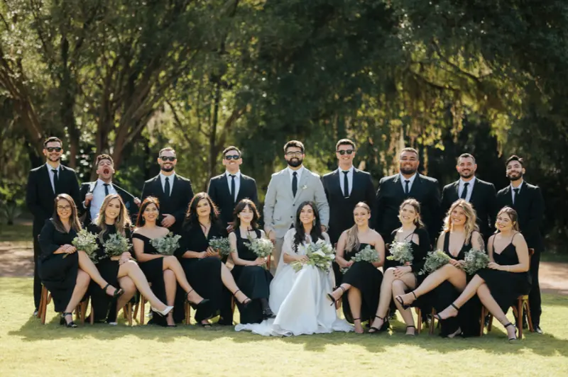 trajes formais de casamento posando para uma foto ao ar livre.