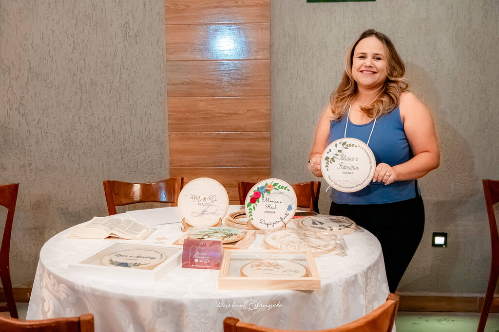 Dê mostrando seus bordados todos colocados em uma mesa