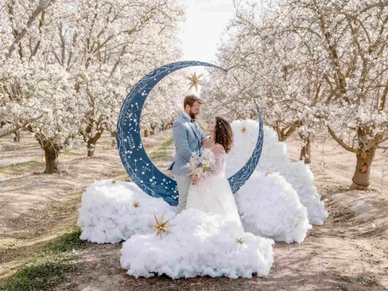 casamento temático celestial e noivos estão em frente a meia lua