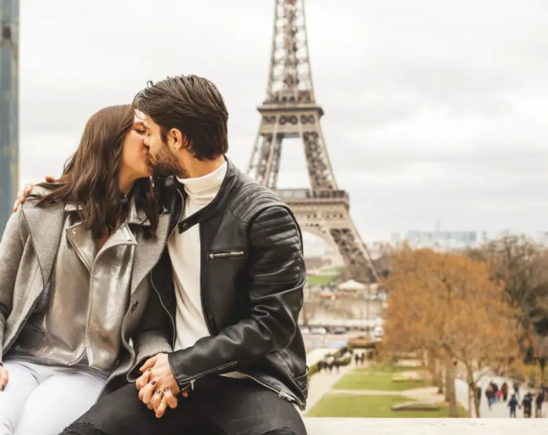 casal se beijando em frente a torre Eiffel
