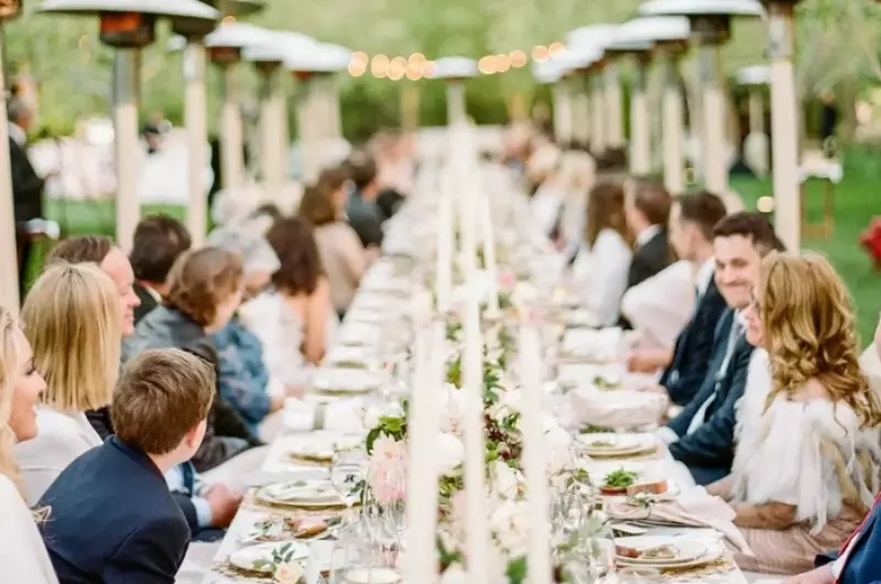 mesa de almo&ccedil;o de casamento com mesa posta com convidados