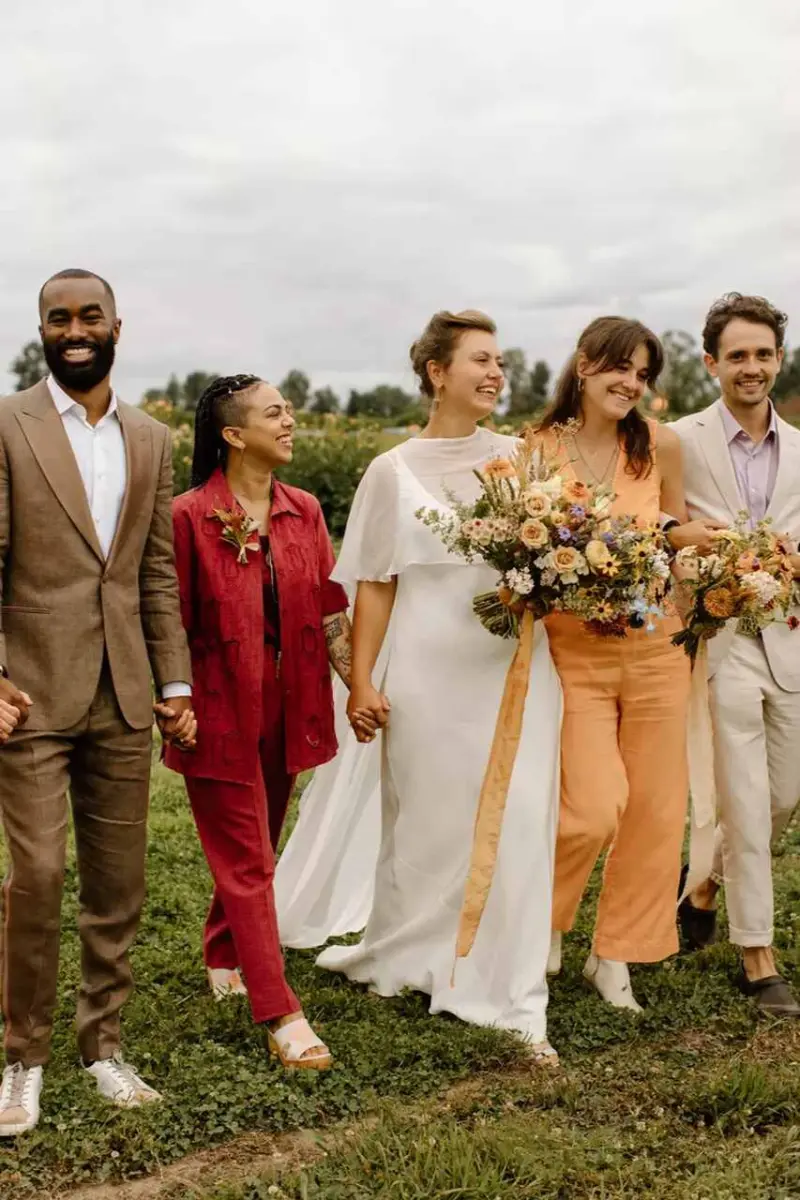 noiva ao lado de padrinhos caminho em campo aberto. Eles estão vestido esporte fino