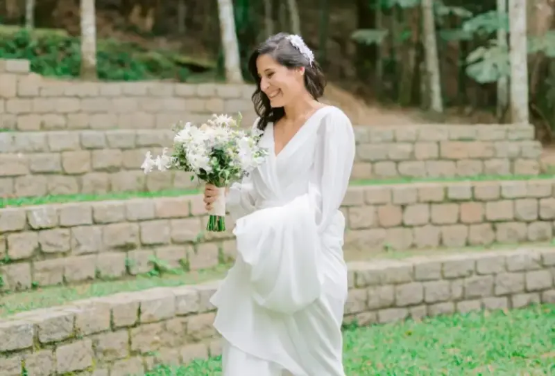 noiva de branco segurando cauda do vestido