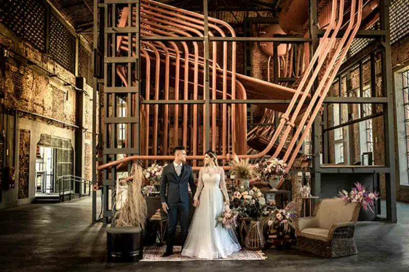 noivos de m&atilde;os dadas em casamento industrial