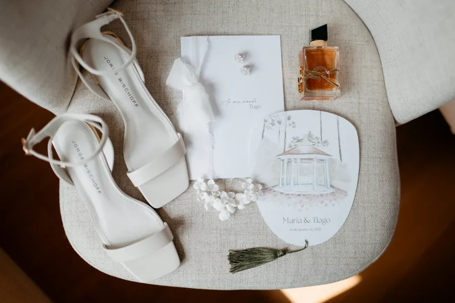 sandalia da noiva ao lado de convite e perfume