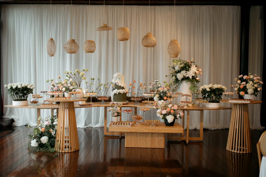 salão com mesa de bolo de casamento com flores