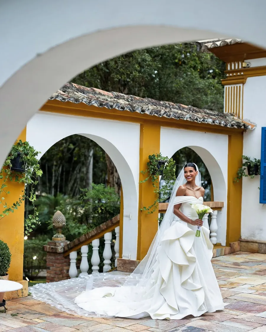 noiva com vestido com babados e buquê com flores brancas