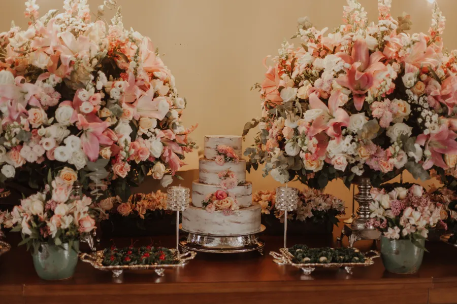 mesa com bolo de casamento rosa