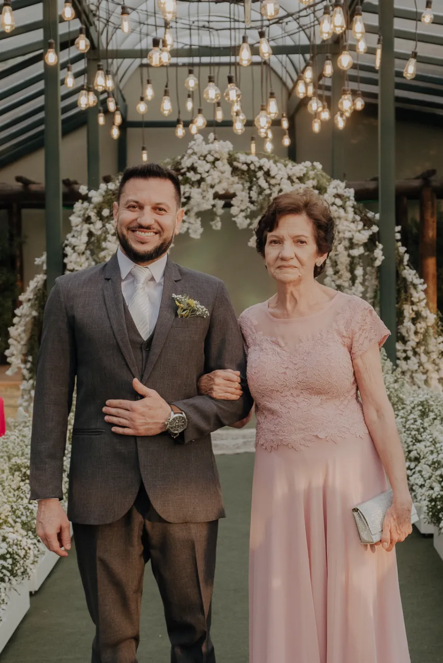 entrada do noivo com terno cinza mãe com vestido rosa