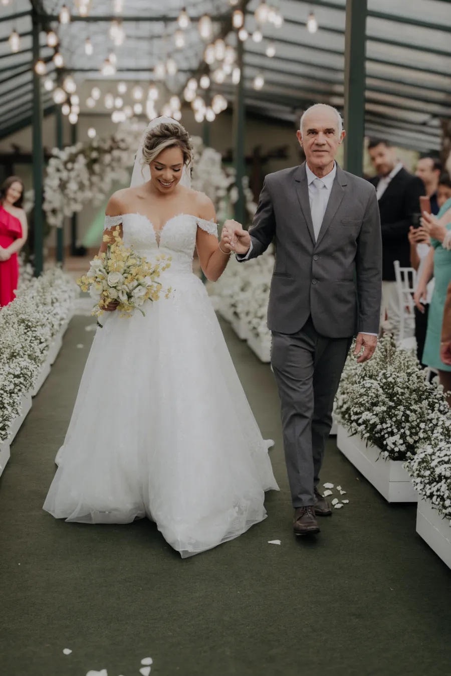entrada da noiva com buque amarelo e pai com terno cinza