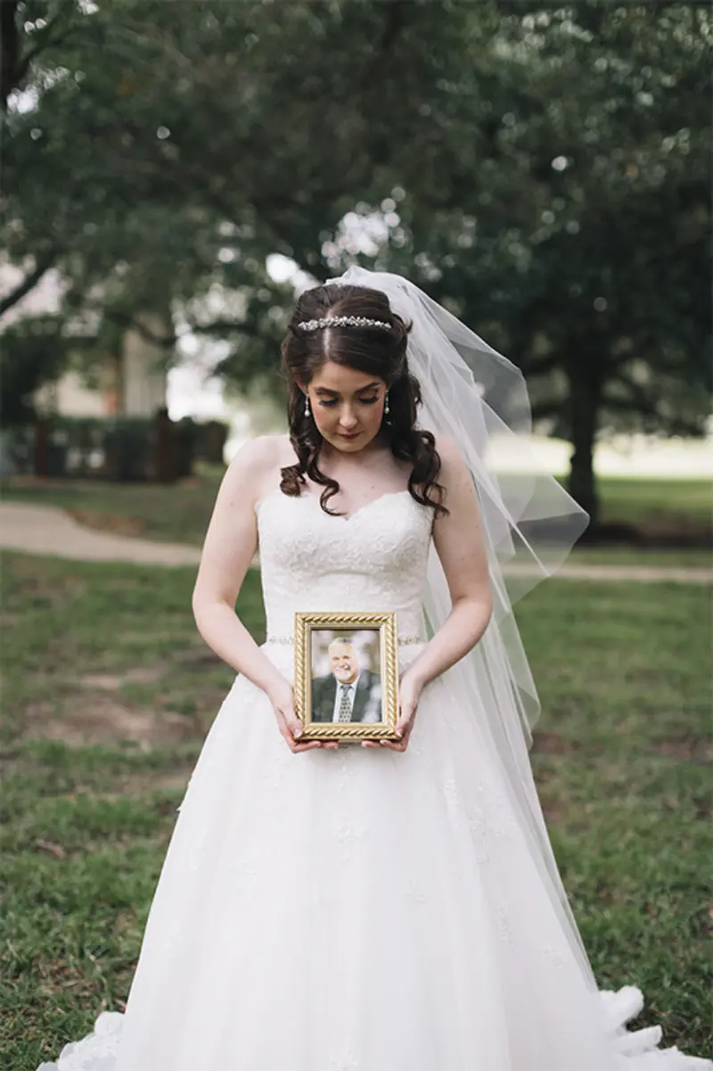 noiva segurando um quadro para homenagem p&oacute;stuma