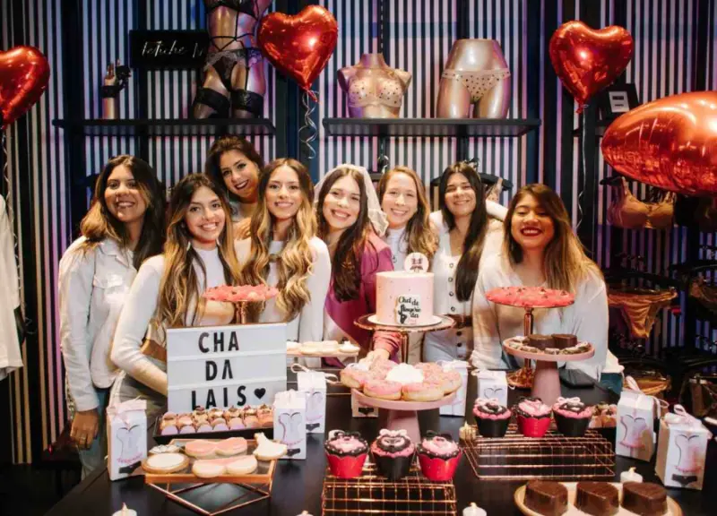 noiva e convidadas em mesa de doces de ch&aacute; de lingerie