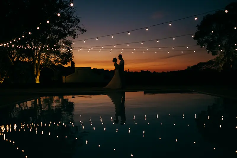 noivos abra&ccedil;ados em casamento ao anoitecer