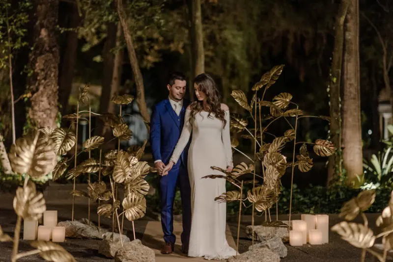 noivos de m&atilde;os dadas em casamento moderno de noite