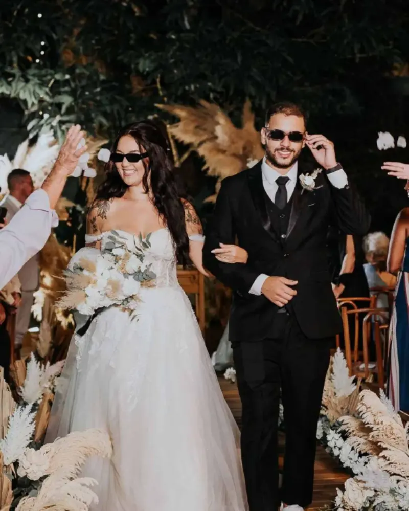 noivos de &oacute;culos escuros na sa&iacute;da da cerim&ocirc;nia