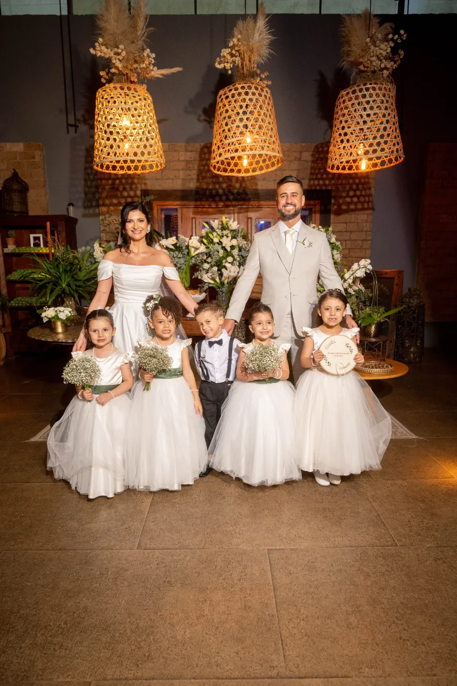 noivos perto de daminahs e pajens