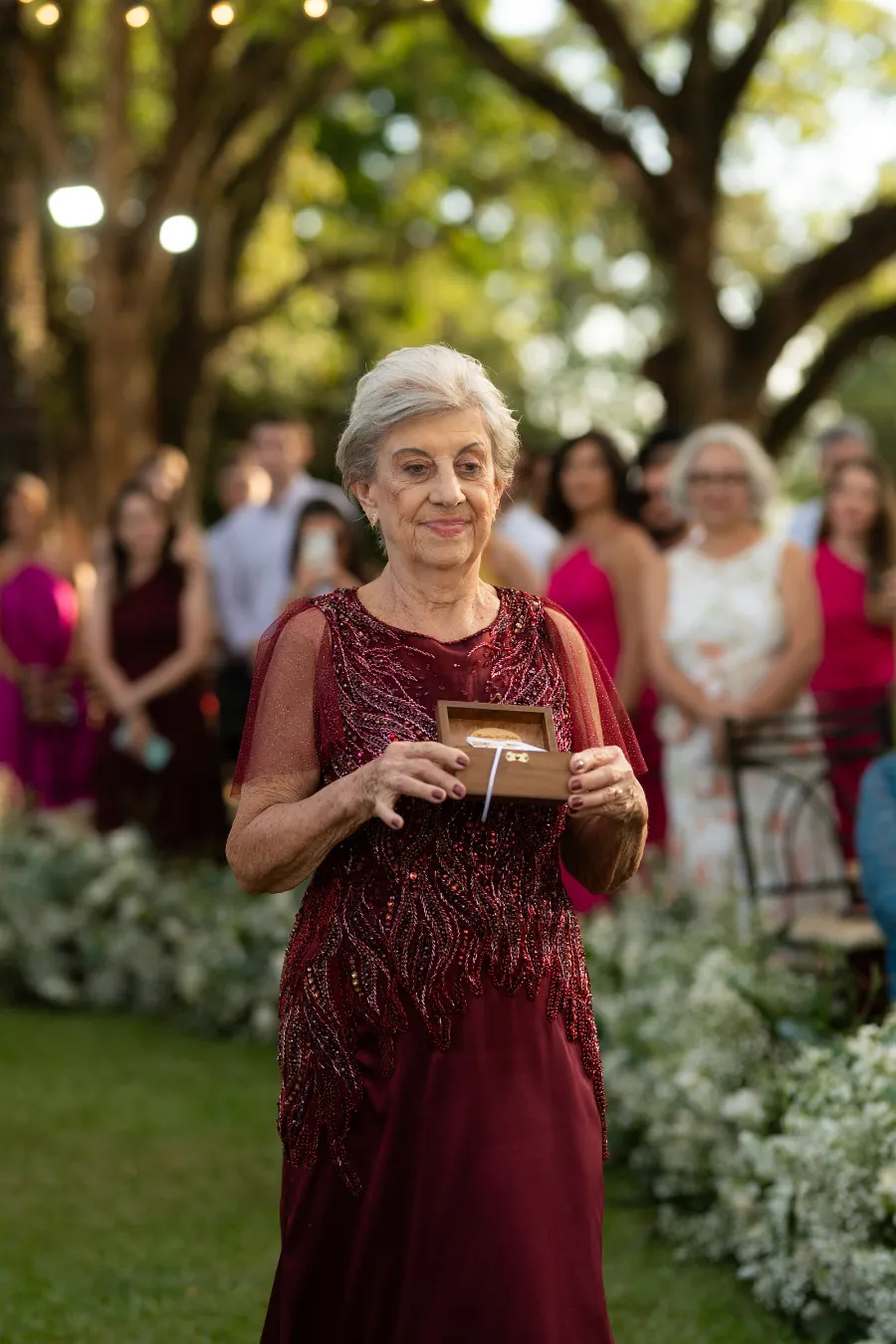 entrada ada avó com vestido bordo carregando porta alianças
