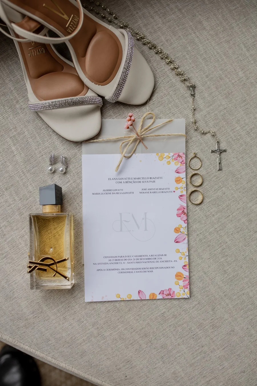 papelaria de casamento colorida ao lado de sandália e perfume