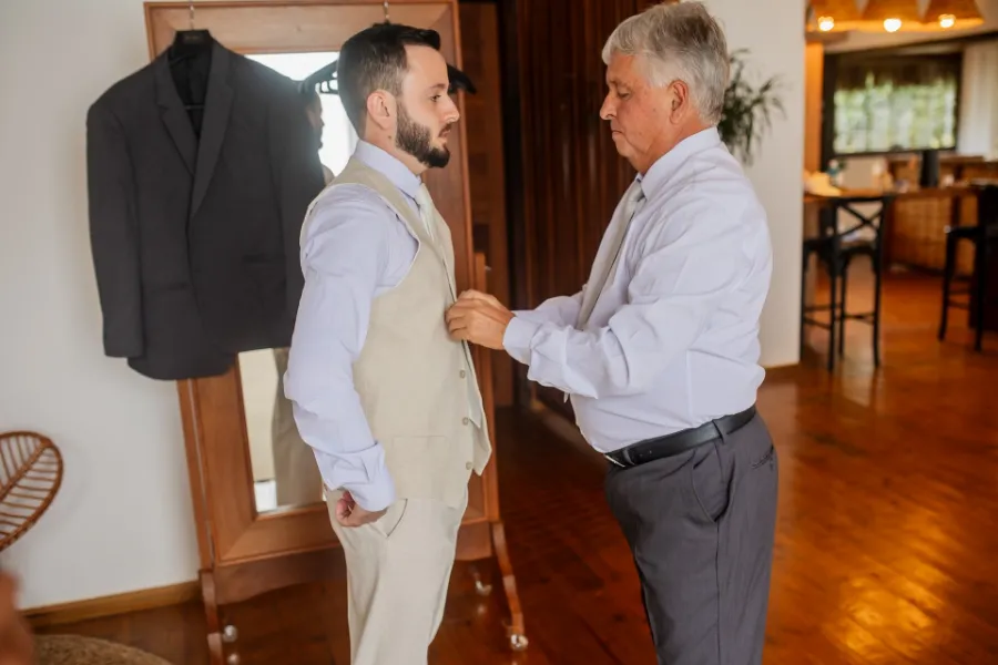 pai do noivo ajustando o terno do noivo