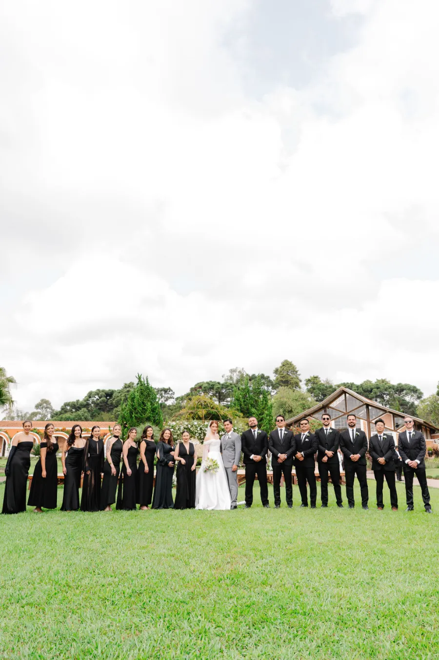 noivos ao lado das madrinhas e padrinhos de preto