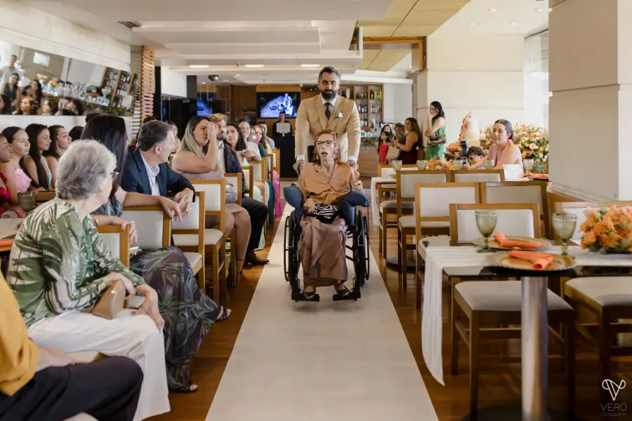 entrada do noivo levando a mãe em uma cadeira de rodas