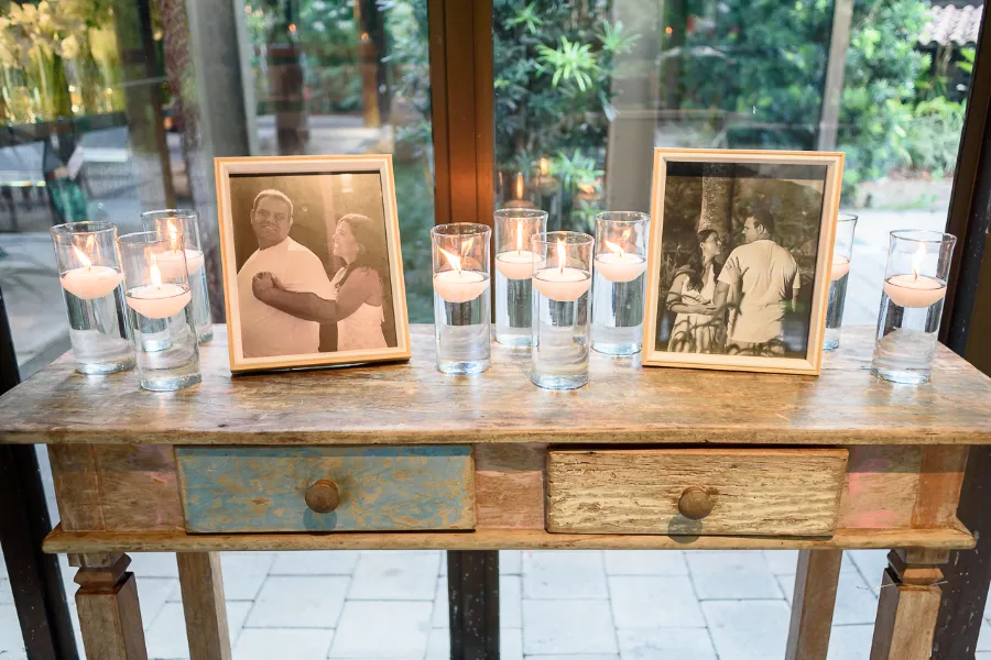 mesa com porta-retratos e velas decorativas