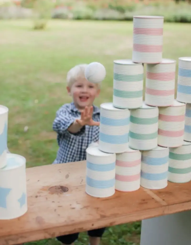 crian&ccedil;a acertando latas em casamento