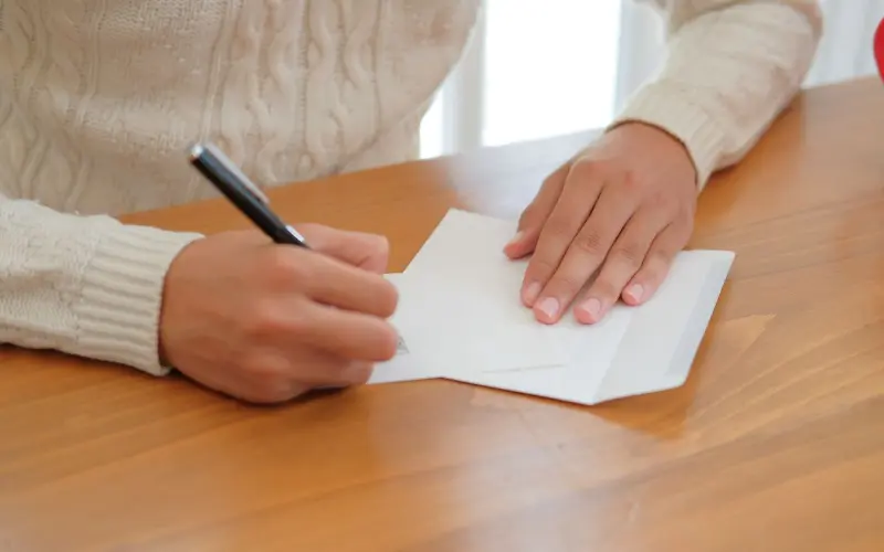 pessoa escrevendo cartão