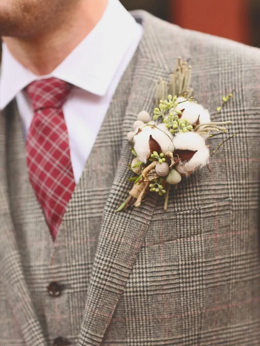 noivo com terno cinza e lapela com algodão branco