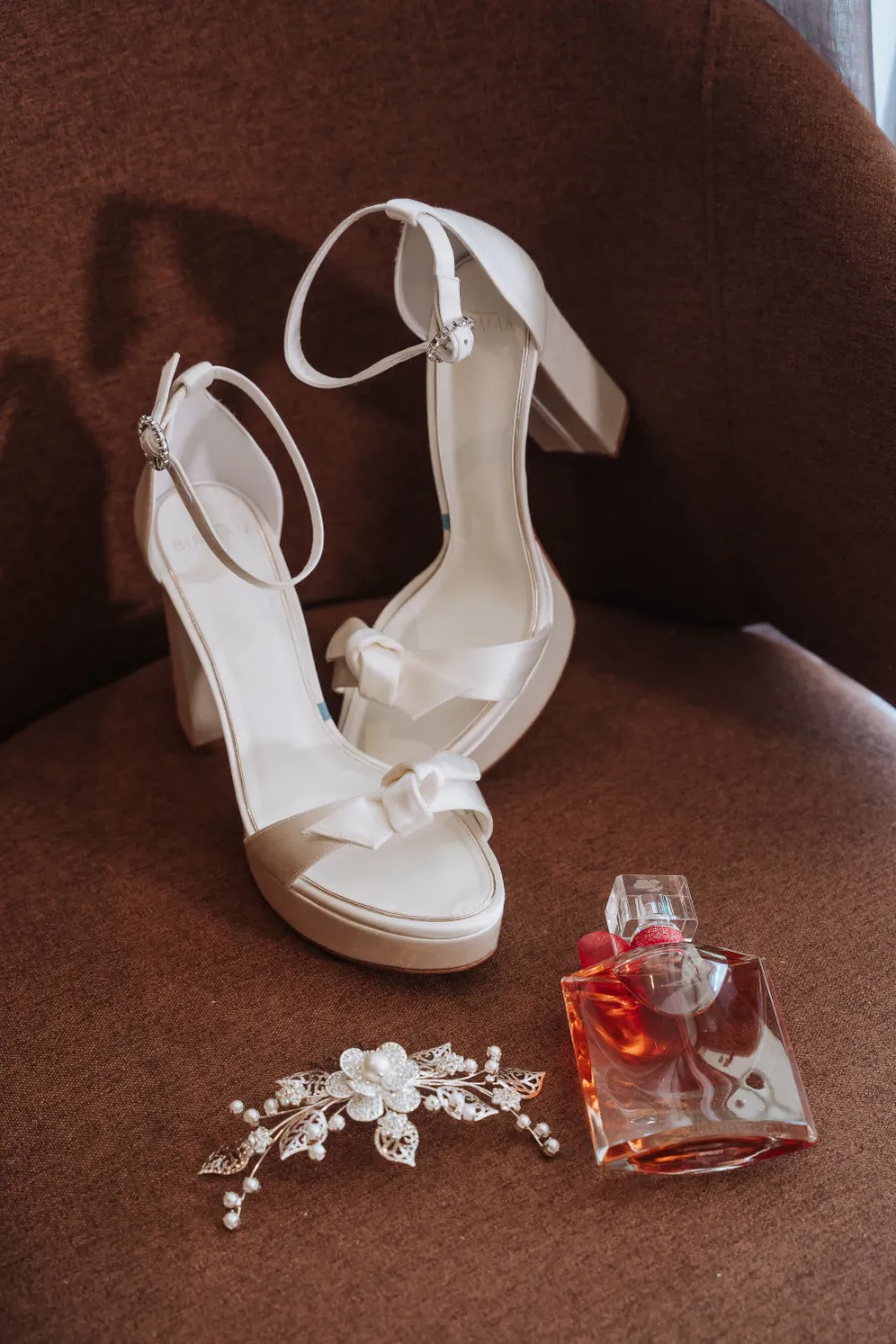 sandalia de noiva ao lado de perfume e grinalda