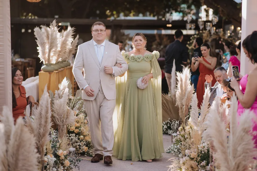 entrada do noivo com a mãe com vestido verde com capa