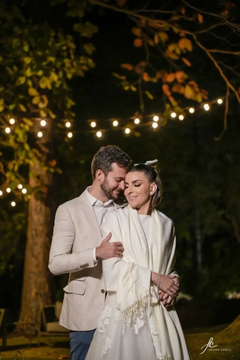 noivos abraçados embaixo de árvore a noite em casamento civil romântico