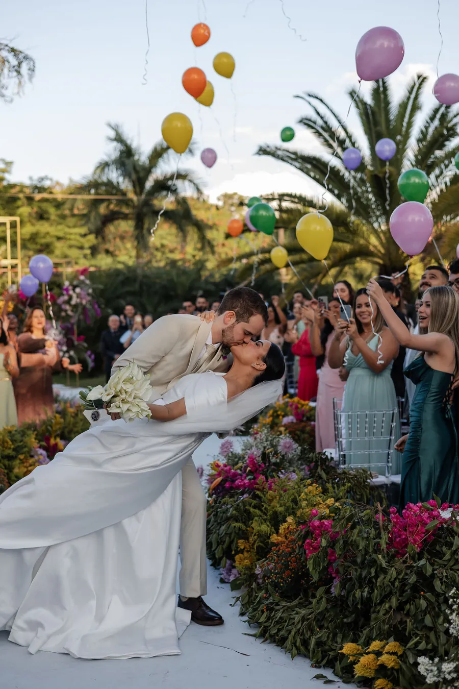 noivos se beijando na saída com balões