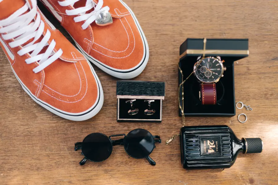 sapato de noivo terracota ao lado de perfume e relogio