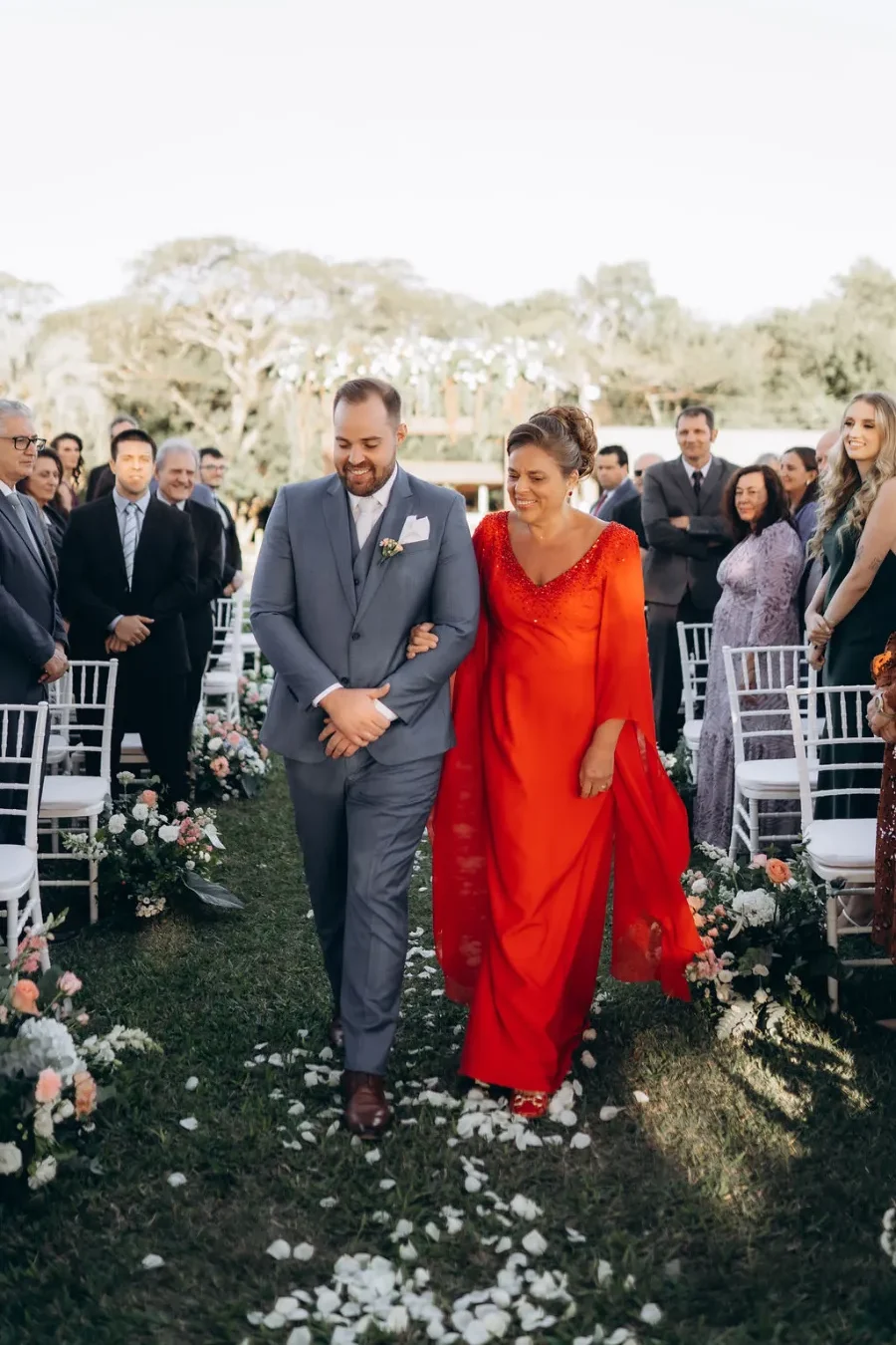 entrada do noivo ao lado da mãe com vestido laranja